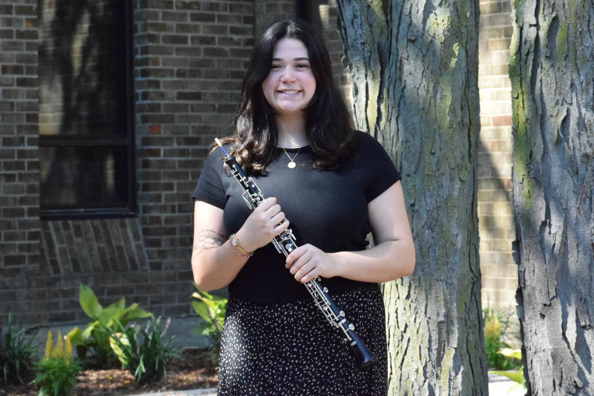 Lea Carter holding her oboe outside.